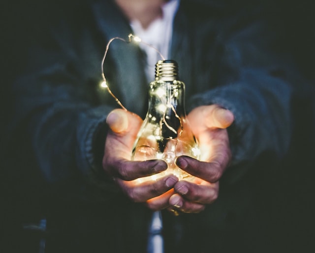 person holding lighted bulb