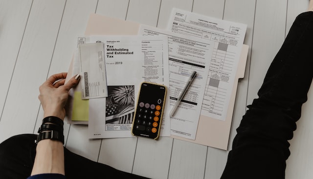 person holding tax paper and calculator