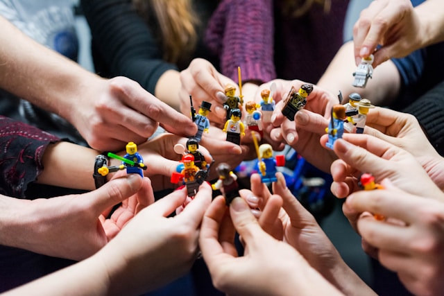people-holding-miniature-figures
